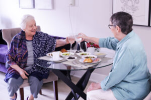 Two female residents toasting in a comfortably furnished apartment